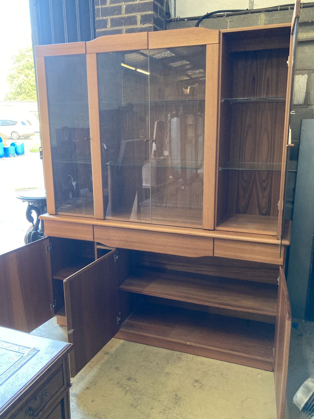 Skovby, Denmark, a teak cabinet fitted plate glass doors over three drawers and three cupboards, width 165cm, depth 47cm, height 196cm